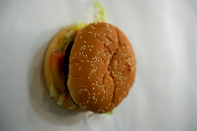 A quarter pounder burger in a sesame seed bun with lettuce and tomato