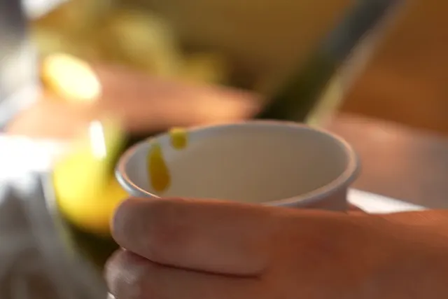 Hot curry sauce being poured into a takeaway pot