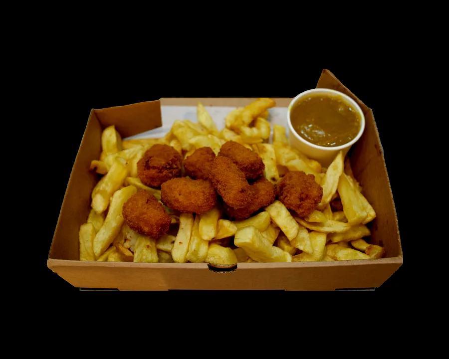 Six golden chicken nuggets scattered over thick-cut chips in an open takeaway box, with a pot of curry sauce