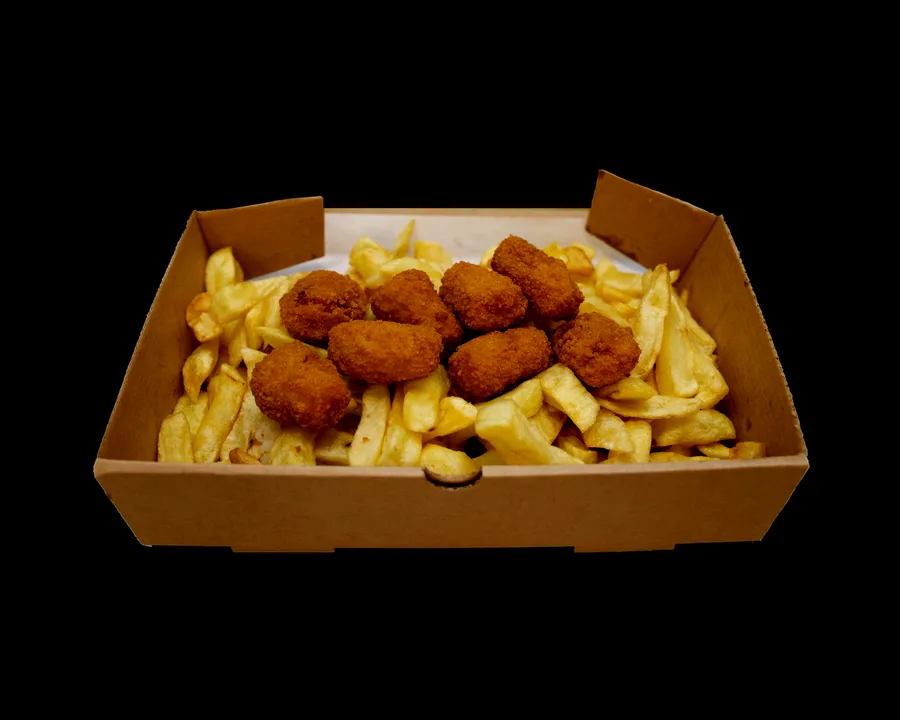 Eight pieces of breaded scampi piled on thick-cut chips in an open takeaway box, with a pot of tartare sauce